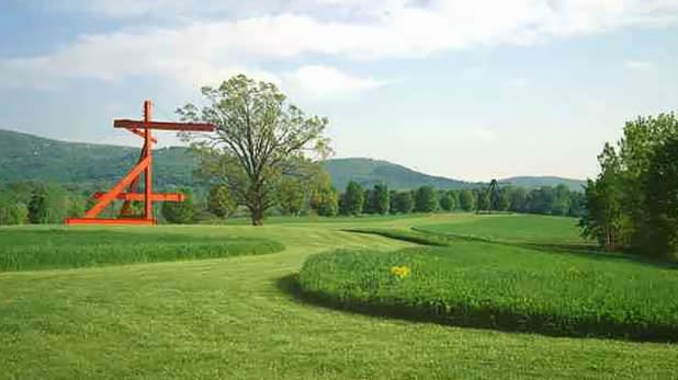 Red sculpture at the Storm King Art Center, surrounded by lush greenery and mountains