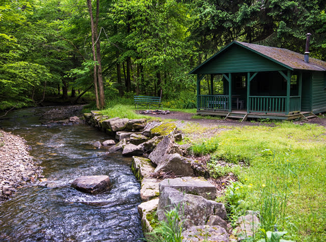 A photo of the exterior of a green cabin at Allegheny State Park