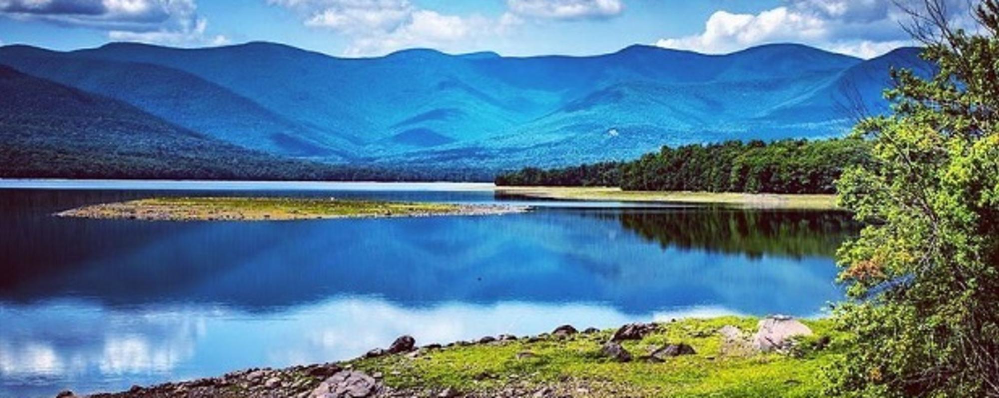 Rolling hills of the Catskill Mountains seen beyond the crisp blue waters of Ashokan Reservoir