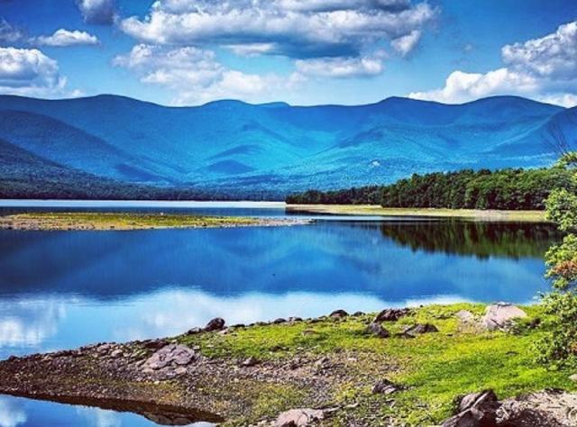 Rolling hills of the Catskill Mountains seen beyond the crisp blue waters of Ashokan Reservoir